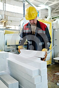 Worker putting stones in stack for production
