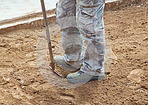 Worker with rake while crushing the ground