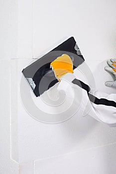 Worker rasping insulation panels