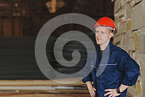Worker in a red cap and uniform stands against the backdrop of t