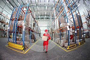 Worker in red uniform with box in warehouse