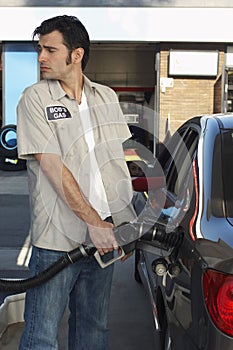 Worker Refueling Car At Station