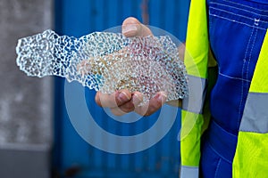 A worker with the remains of a broken toughened glass in his hands photo
