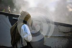 Worker is remove paint by air pressure sand blasting photo