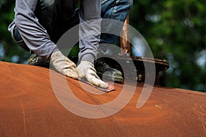 Worker is remove paint by sand paper