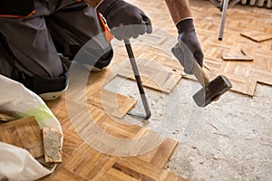 Worker removes old fparquet, renovation home