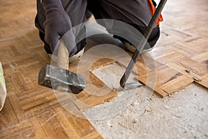 Worker removes old fparquet, renovation home