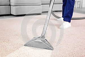 Worker removing dirt from carpet, closeup. Cleaning service