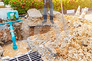 Worker repair pipe plumbing water main broken. Use shovel to dig a hole underground on the road