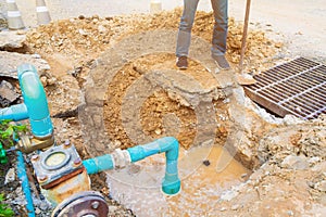 Worker repair pipe plumbing water main broken. Use shovel to dig a hole underground on the road
