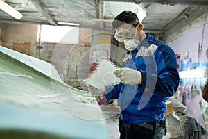 Worker repairing boat in workshop