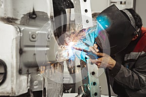 Worker repairing car body with carbon dioxide welding. Weld of auto.