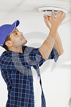 worker repairing ceiling air conditioning unit