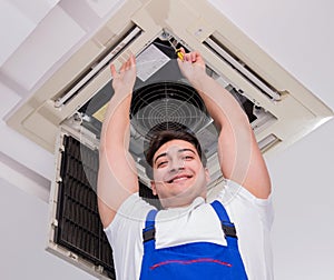 Worker repairing ceiling air conditioning unit