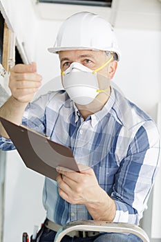 worker repairing ceiling air conditioning unit