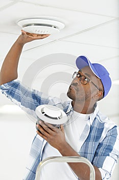 worker repairing ceiling air conditioning unit