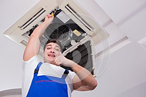 The worker repairing ceiling air conditioning unit