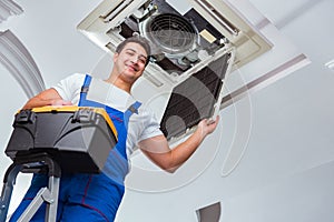 The worker repairing ceiling air conditioning unit