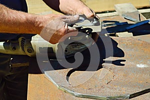 a worker replaces a grinding disc on a grinding machine that is wasted during metal cutting