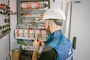 Worker restores the connection in the data center server room. Engineer in a helmet will connect damaged Internet backbone wire.