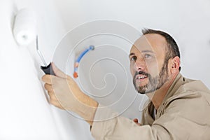 Worker roller painting wall