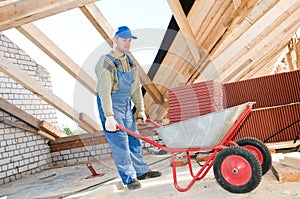 Worker roofer and wheel barrow