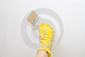 worker with rubber gloves painting a wall with paint brush.Side view home renovation apartment improvement.Painter