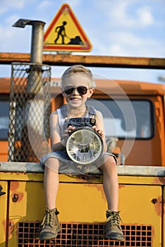 The worker`s boy sits on a yellow, large excavator.