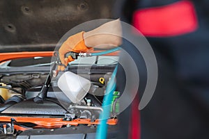 worker's hand cricks gloves using a blower to clean the engine