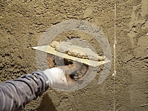 Worker`s hand with a mortar on a plaster trowel