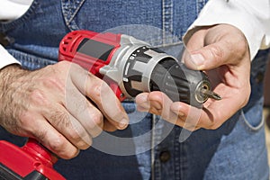 The worker`s hands hold the screwdriver