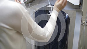 Worker`s hands putting packaging on cleaned suit