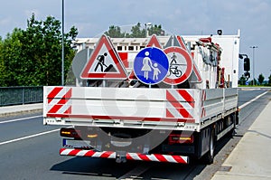 A worker`s truck with roadsigns at a road construction site