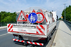 A worker`s truck with roadsigns at a road construction site