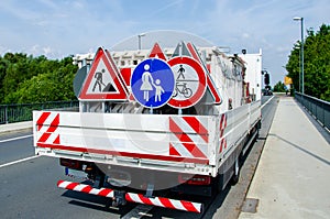 A worker`s truck with roadsigns at a road construction site