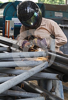 Worker with safety equipment and protective mask welding.