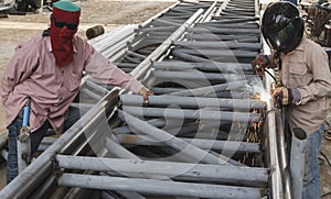 Worker without safety protective welding steel structure.