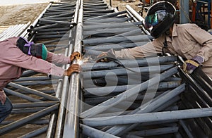 Worker without safety protective welding steel structure in cons