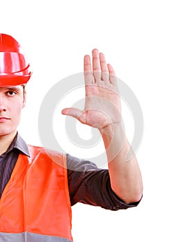 Worker in safety vest hard hat showing stop hand