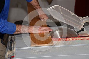 Worker sawing off the floorboard