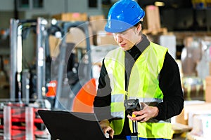 Worker with scanner and laptop at forwarding photo