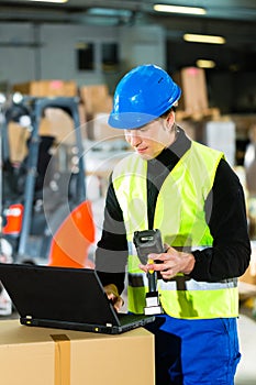 Worker with scanner and laptop at forwarding