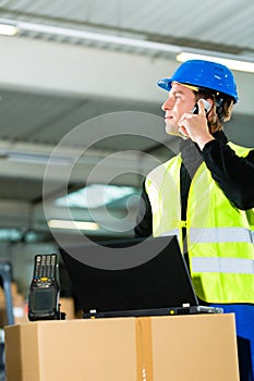 Worker with scanner and laptop at forwarding