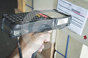 Worker scanning bar code scanner with label of goods. Computer equipment for warehouse inventory management.