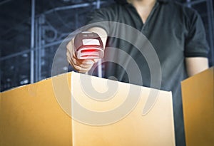 Worker scanning barcode scanner with red laser on parcel box. Shipment, Computer equipment for warehouse inventory management