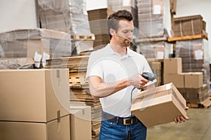 Worker scanning package in warehouse