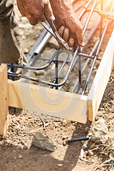 Worker Securing Steel Rebar Framing With Wire Plier Cutter Tool