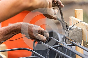 Worker Securing Steel Rebar Framing With Wire Plier Cutter Tool