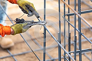 Worker Securing Steel Rebar Framing With Wire Plier Cutter Tool