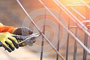 Worker Securing Steel Rebar Framing With Wire Plier Cutter Tool photo